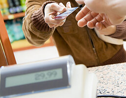 woman doing shopping in a grocery store and paying by credit card